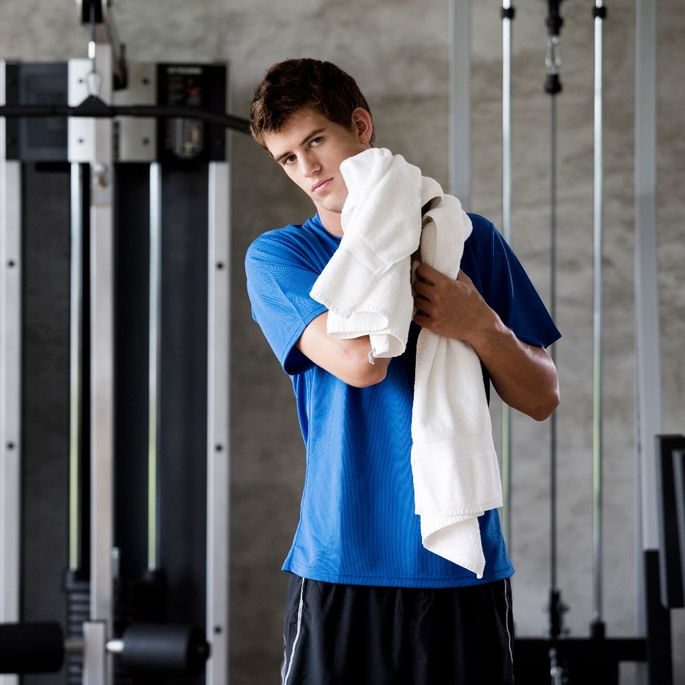 Fitness center member using clean towels from commercial towel laundry service