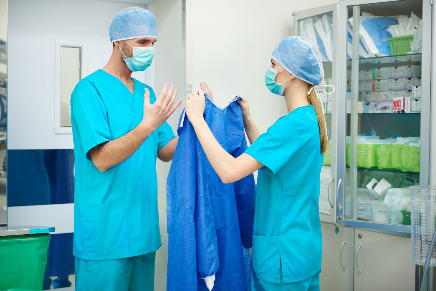 Medical staff handling clean surgical gowns for healthcare laundry service